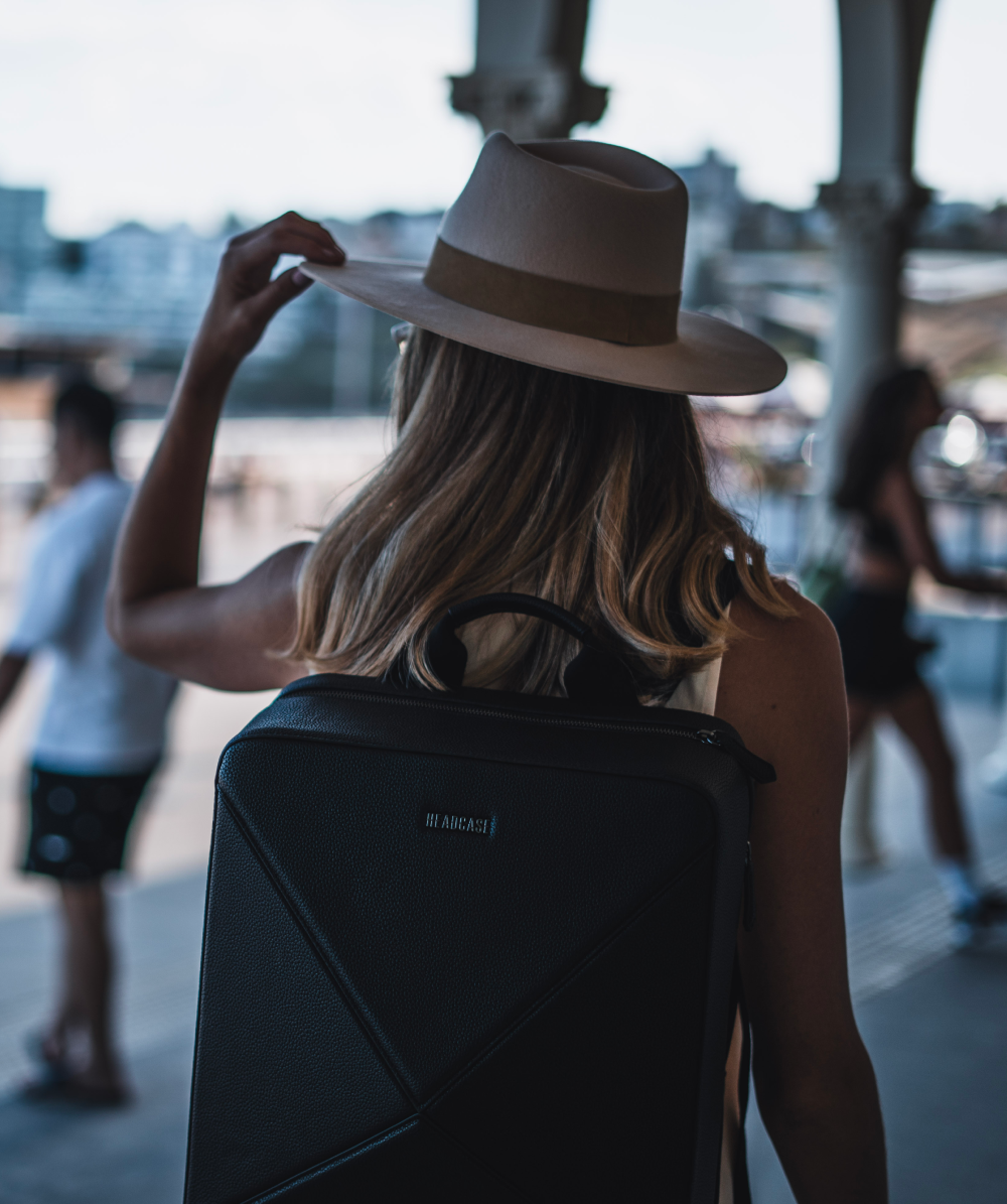 traveler with hat posing with headcase backpack byron boho noir black backpack