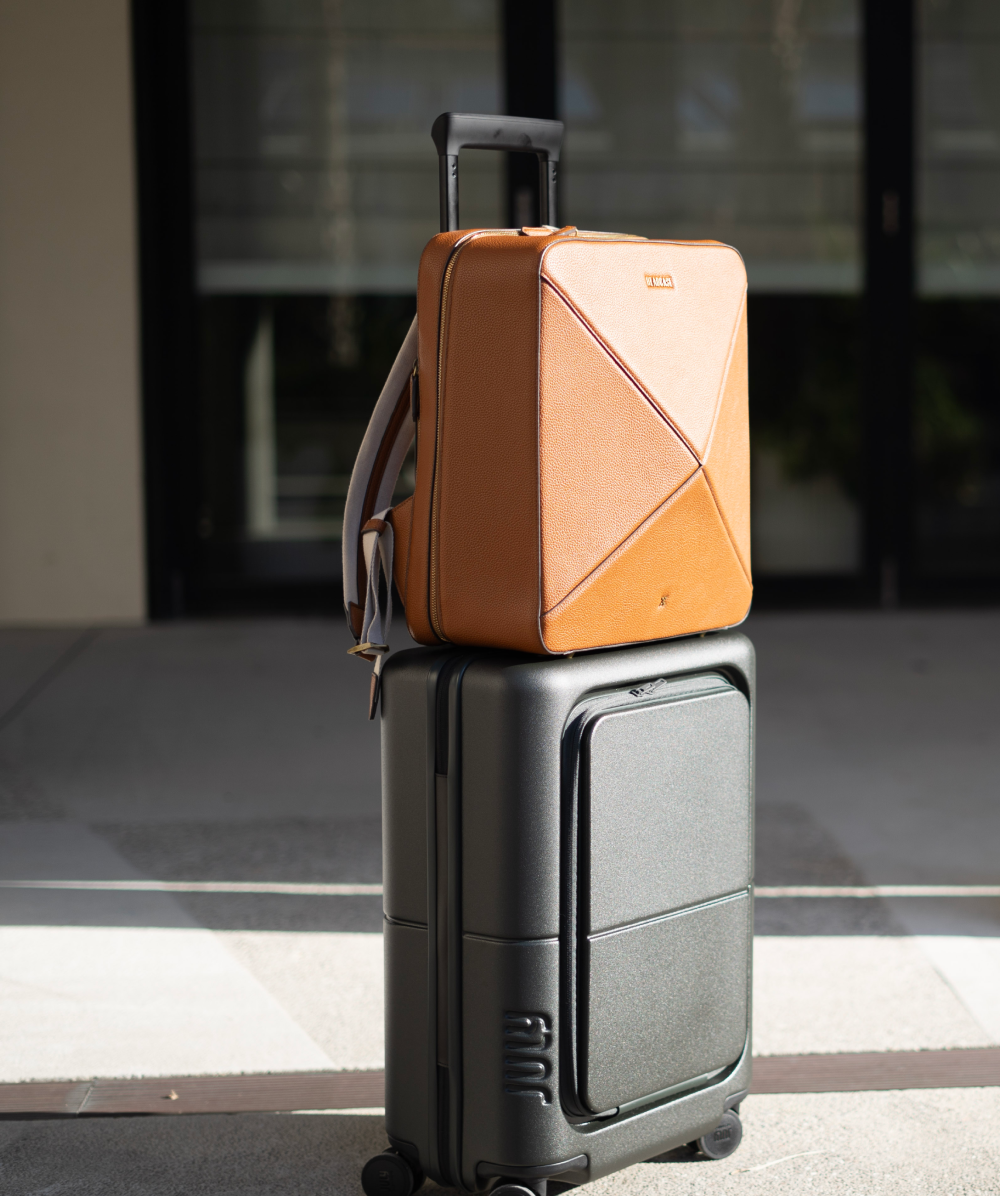 headcase backpack bondi bombshell tobacco brown backpack on top of carry on luggage facing the sunlight